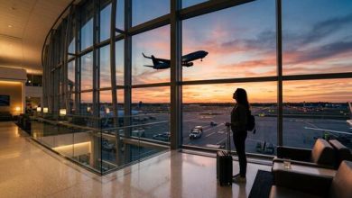 silhouette of female traveler watching airplane takeoff from airport window at sunset photo